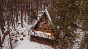 a-frame nestled in the woods during winter time in the Adirondacks